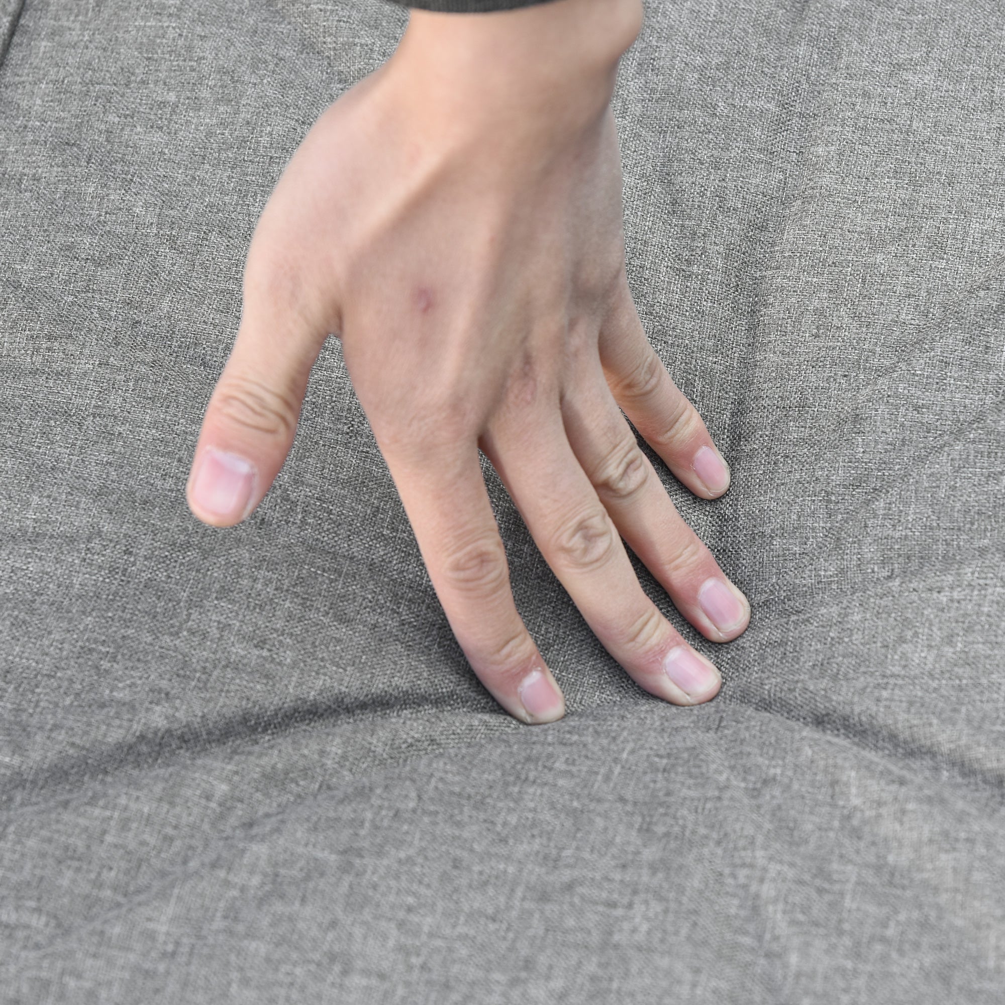 Hand on gray fabric surface