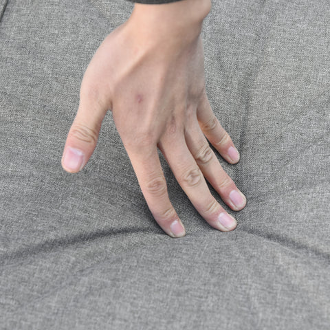 Hand on gray fabric surface
