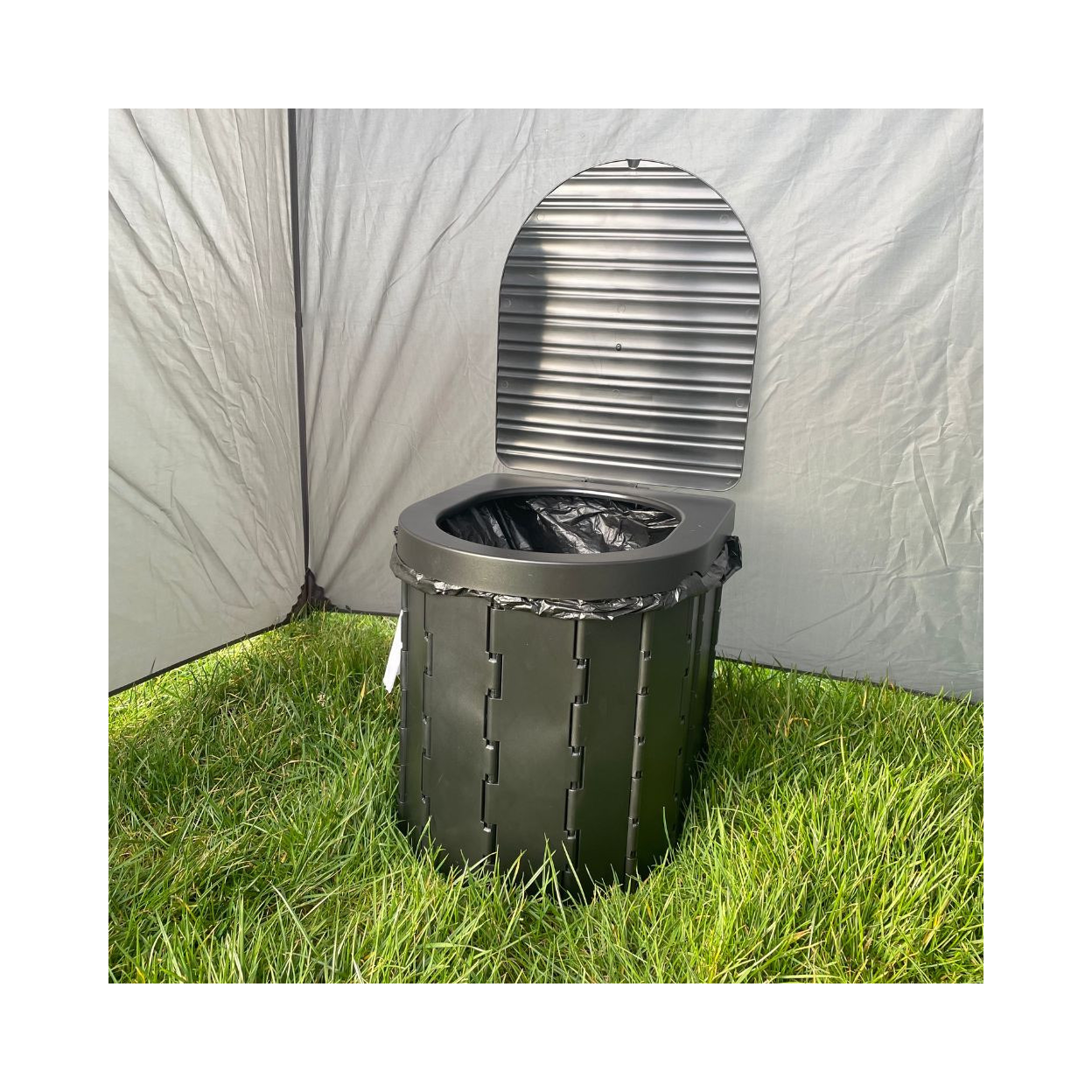 Green trash can with metal liner against a white tent background