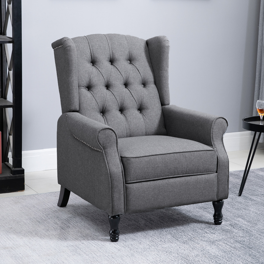 Gray tufted armchair in a room with a side table and bookshelf.