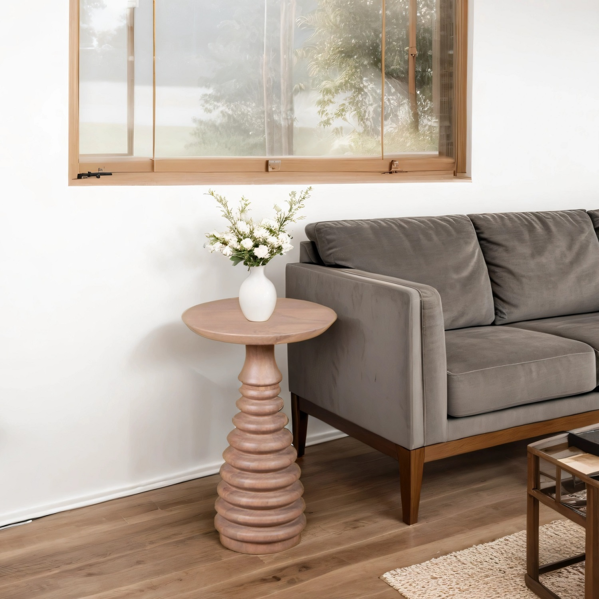 Living room with a gray sofa, wooden side table, and decorative elements.