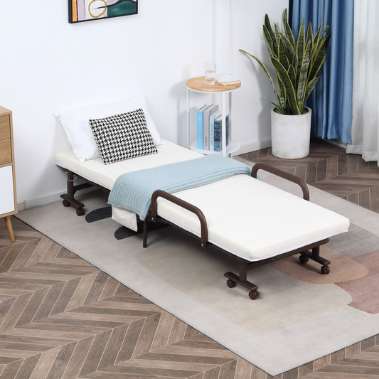Foldable bed in a room with a plant and books on a small table.