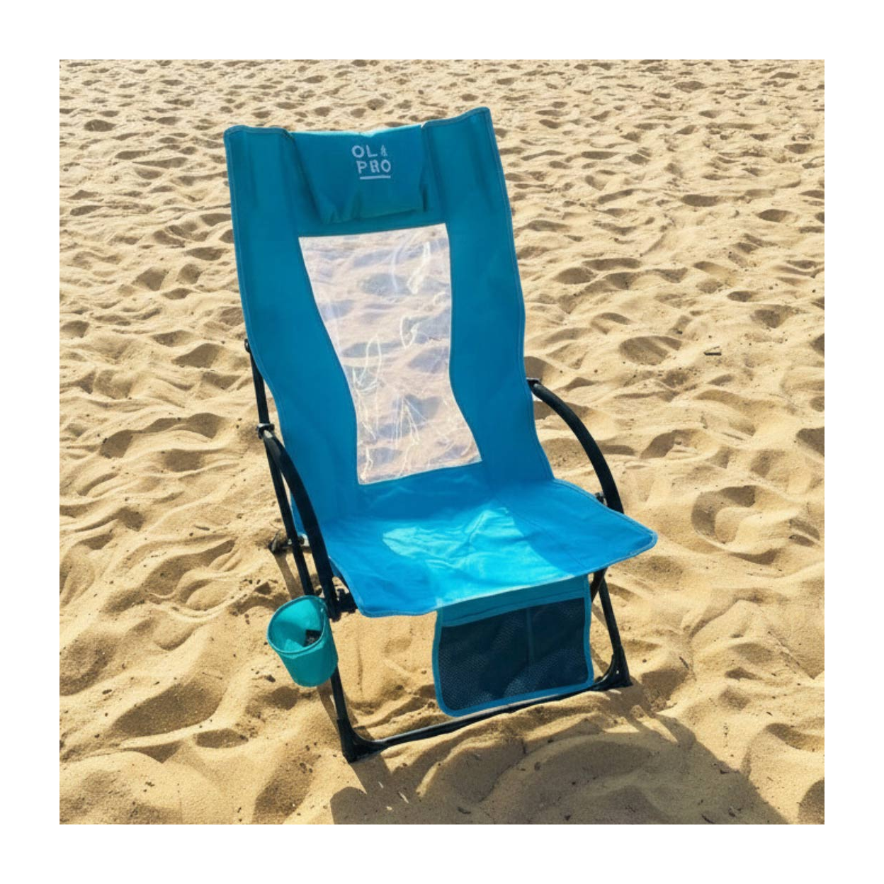 A blue beach folding chair with a clear back panel and black metal frame, set on sandy beach ground with a small matching blue cup attached.