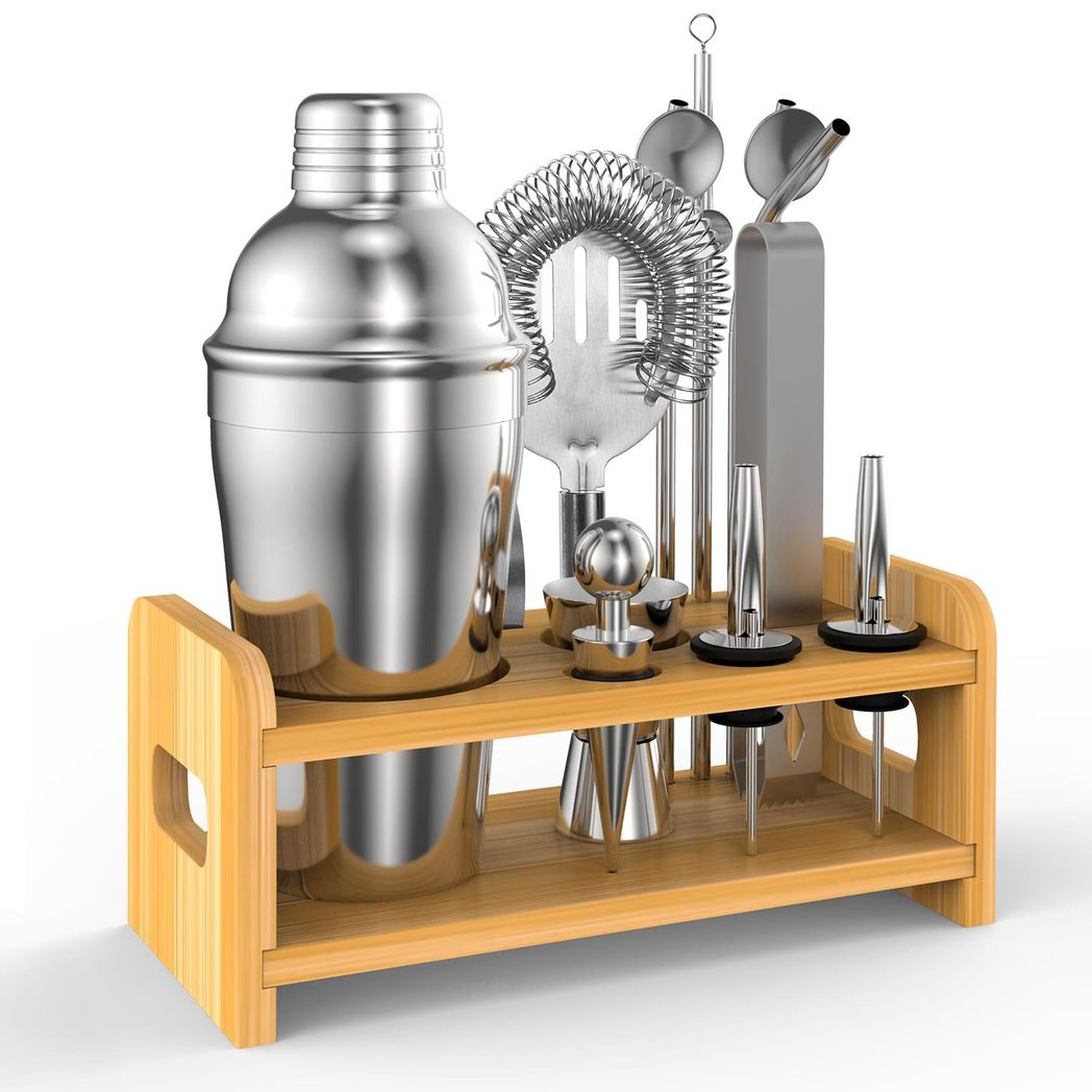 Set of cocktail-making tools including a shaker and jiggers on a wooden stand.