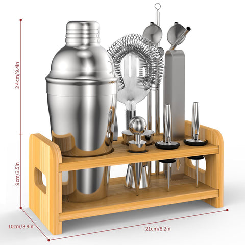 Set of cocktail-making tools including a shaker and jiggers on a wooden stand.