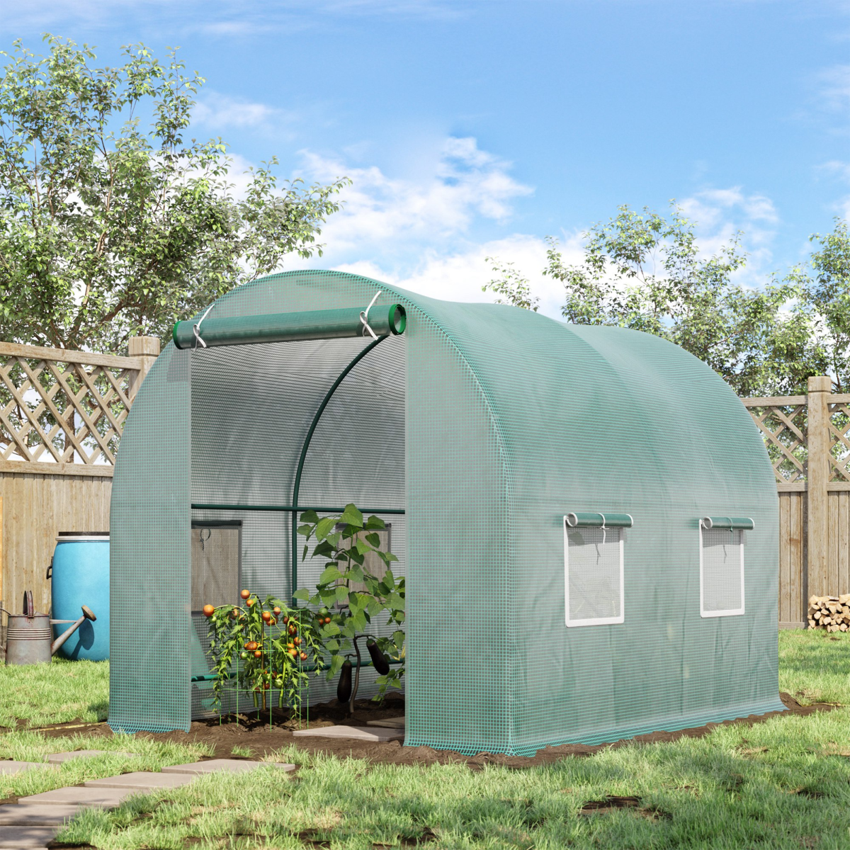 Green greenhouse in a backyard with plants inside, surrounded by trees and a wooden fence.